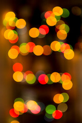 Fototapeta premium Multicolored colorful bokeh lights on abstract dark background. Vertical photo