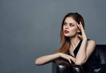 Woman in black dress gestures with her hands on gray background Copy Space © SHOTPRIME STUDIO