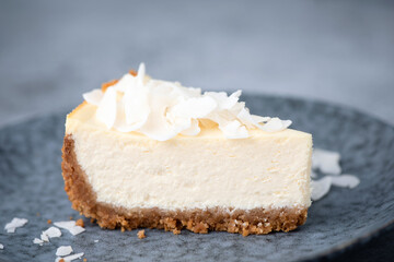 Slice of vegan coconut cheesecake on a plate. Coconut cashew cheesecake