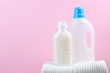 Laundry detergent bottles and woolen sweaters on the table. Household chemicals