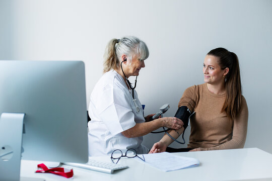 Doctor checking patients blood pressure, Sweden