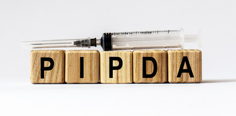 Text PIPDA made from wooden cubes. White background