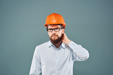 Man in orange hard hat shirt cropped view blue background construction work