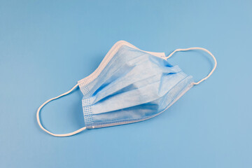 Blue protective medical mask on blue table. Front view.