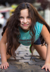 Niña de ojos claros sonriente con el cabello suelto y una bonita expresión de alegría 