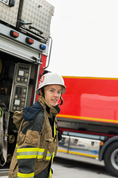 Female firefighter by fire engine, Sweden
