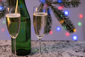 a bottle of champagne and two full glasses of champagne are on the table