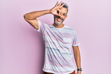 Middle age grey-haired man wearing casual clothes smiling happy doing ok sign with hand on eye...