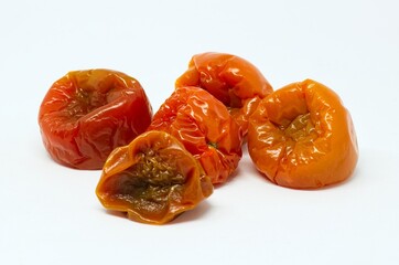 Rotten red cherry tomatoes isolated on white background. Still life studio photography