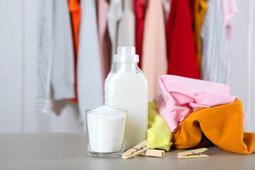 Laundry detergent bottles and clothes on the table. Household chemicals