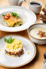 Traditional russian salad mimosa with boiled vegetables, fish, mayonnaise and grated egg, restaurant serving