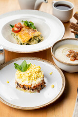 Traditional russian salad mimosa with boiled vegetables, fish, mayonnaise and grated egg, restaurant serving