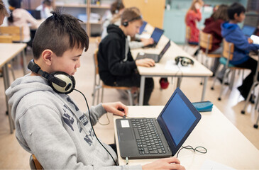 Boy in classroom using laptop, Sweden