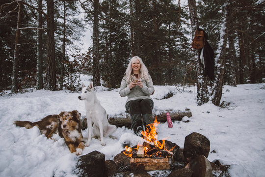 Woman Sitting Near Log Fire At Winter, Sweden