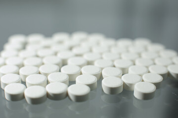 Fototapeta na wymiar White pills on glass table