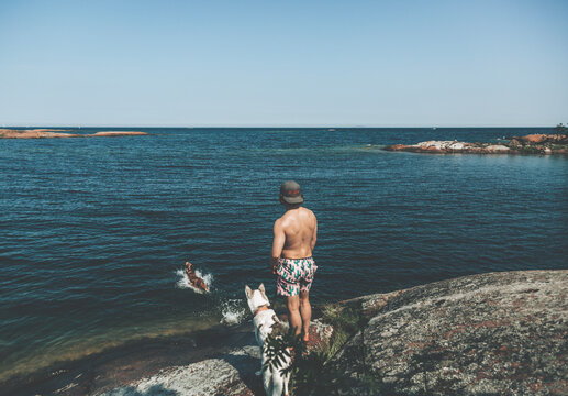 Man with dogs at sea, Sweden