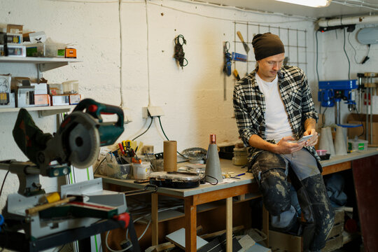 Man using phone in workshop, Sweden