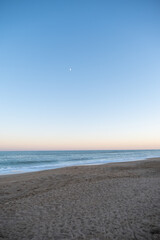 Fototapeta na wymiar Sunset on the beach with half moon and sand