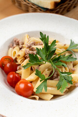 Italian penne pasta with cherry tomatoes and minced meat, close up