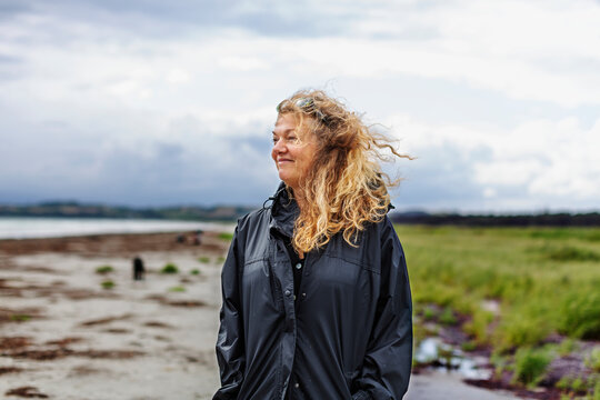 Smiling woman standing on beach, Denmark