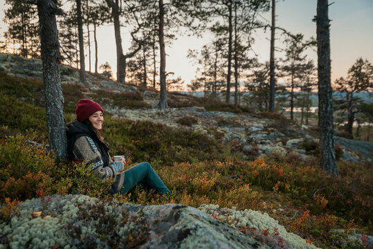 Female hiker relaxing with cup of coffee, Sweden