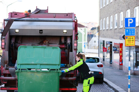 Woman operating garbage truck, Sweden