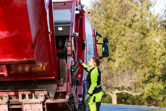 Woman operating garbage truck, Sweden