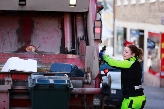 Woman operating garbage truck, Sweden