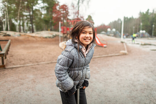 Happy girl on pogo stick looking at camera, Sweden