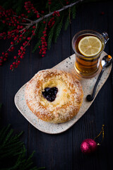 Hot baked round bun with sweet filling for Christmas morning. Festive home made dessert with glass of black tea . New year decoration, family time celebration. 