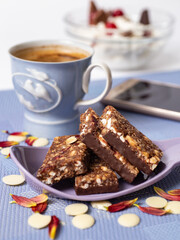 Granola bar. Healthy sweet dessert snack and breakfast. Cereal granola bar with nuts, chocolate, fruit and berries and coffe on a light blue background