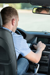 man finger pressing the emergency lights button while driving