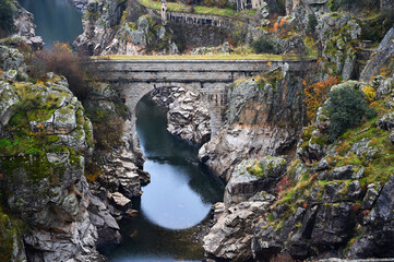 viejo puente sobre un rio entre las monta&ntilde;as