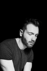 Portrait of a man on a dark background.The look is not in the frame. Vertical.