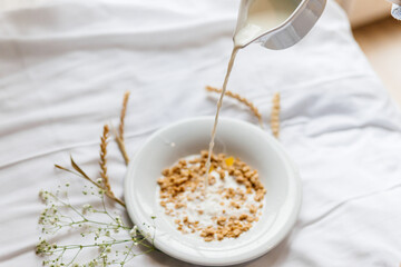 plate with breakfast on a white bed with flowers