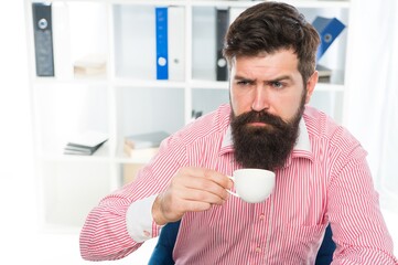 Sleepy half-awake hipster drink cup of coffee in workplace, caffeine