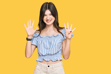 Young beautiful caucasian girl wearing casual clothes showing and pointing up with fingers number...