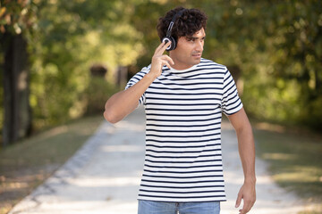 man walking along path listening to headphones