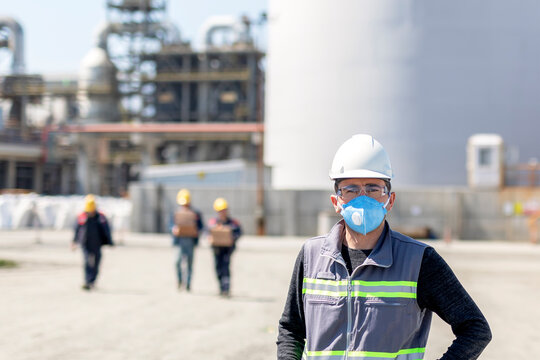 The worker is using a protective face mask for pandemic (covid-19, coronavirus) in the construction site. The group of viruses cause respiratory tract infections that can range from mild to lethal.