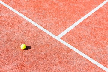 High angle view of tennis ball on red court during sunny day