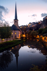 Church of Saint John in Grund, Neimenster, Luxembourg historical centre at sunset with reflection in the water