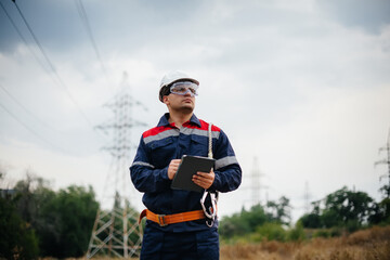 Naklejka premium An energy worker inspects power lines. Energy