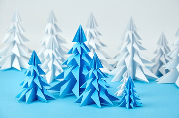 White and blue paper origami christmas trees composition