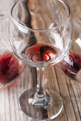 Close-up view of glass with the remains of red wine on on a rustic wooden background. Copy of the space. Alcoholic drinks concept.