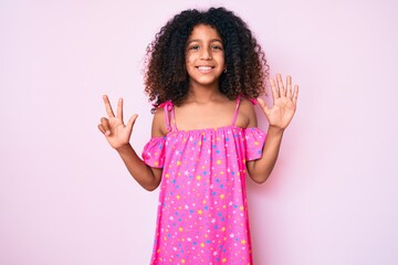 African american child with curly hair wearing casual dress showing and pointing up with fingers number eight while smiling confident and happy.