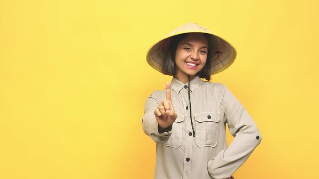 Young latin woman with vietnamite hat  showing number one with finger