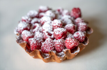 Delicious cake basket with raspberries and powdered sugar