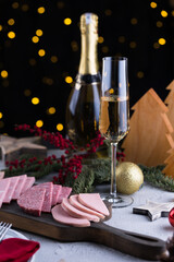 Two glasses of sparkling champagne at New year eve night with clock and bokeh background. Christmas decoration dinner table setting, copy space