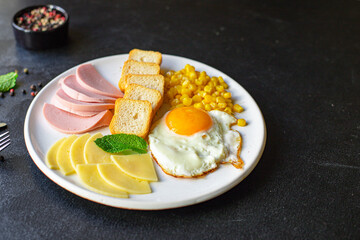 English breakfast fried egg, bread toast, vegetables, corn, cheese and more ready to eat on the table serving healthy meal snack ingredient top view copy space for text food background rustic