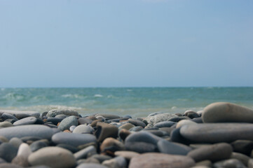 Beach. View of the sea and smooth horizon from the pebble beach. In the foreground are large pebble stones. It's a focus. Background for blog or site, photowallpaper for computer.